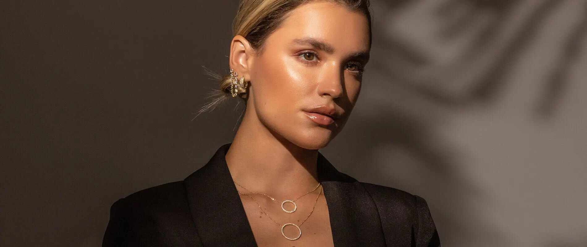 A woman wearing layered jewelry, showcasing styles you can discover when searching for joyeria near me.