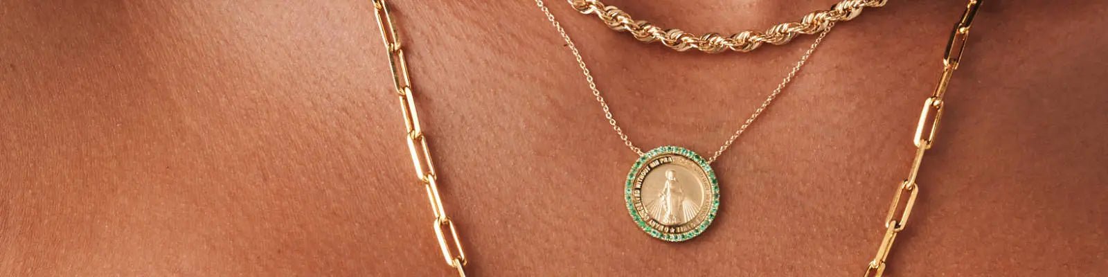 A close-up of a woman's neck wearing necklaces