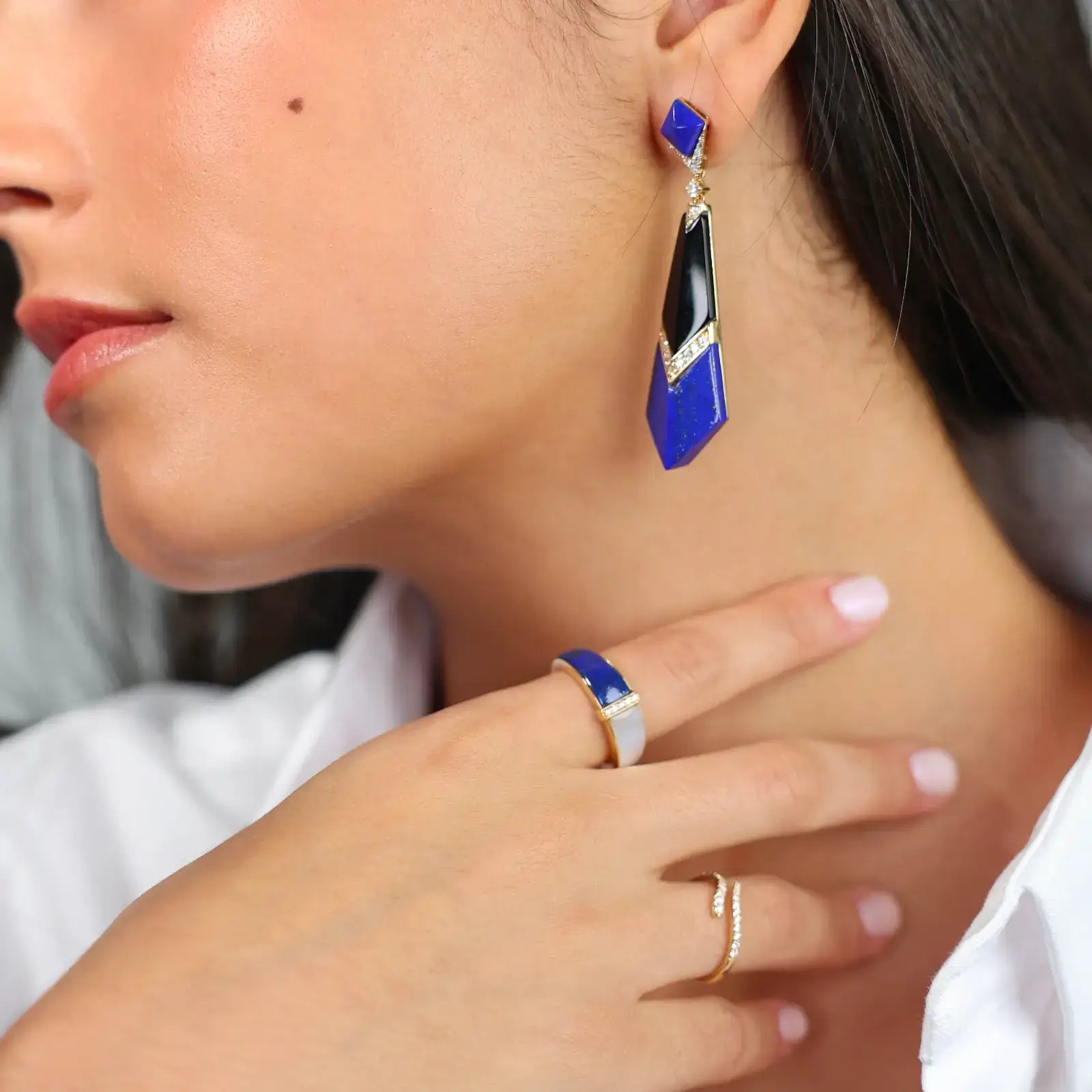 Sculptural lapis and lazuli drop earrings featuring onyx and diamonds on a woman, highlighting bold design.