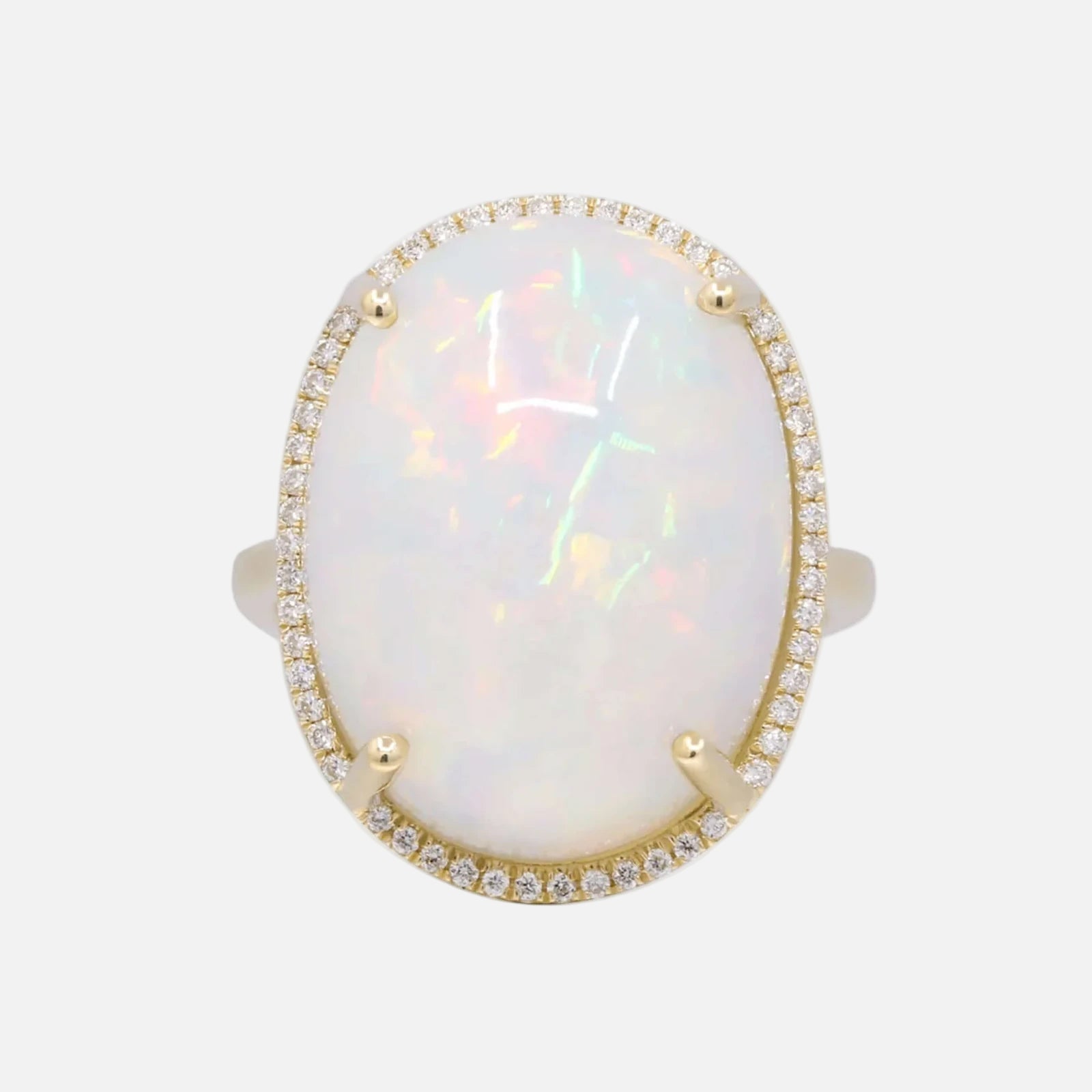 Ring with a large opal stone and gold accents on a white background