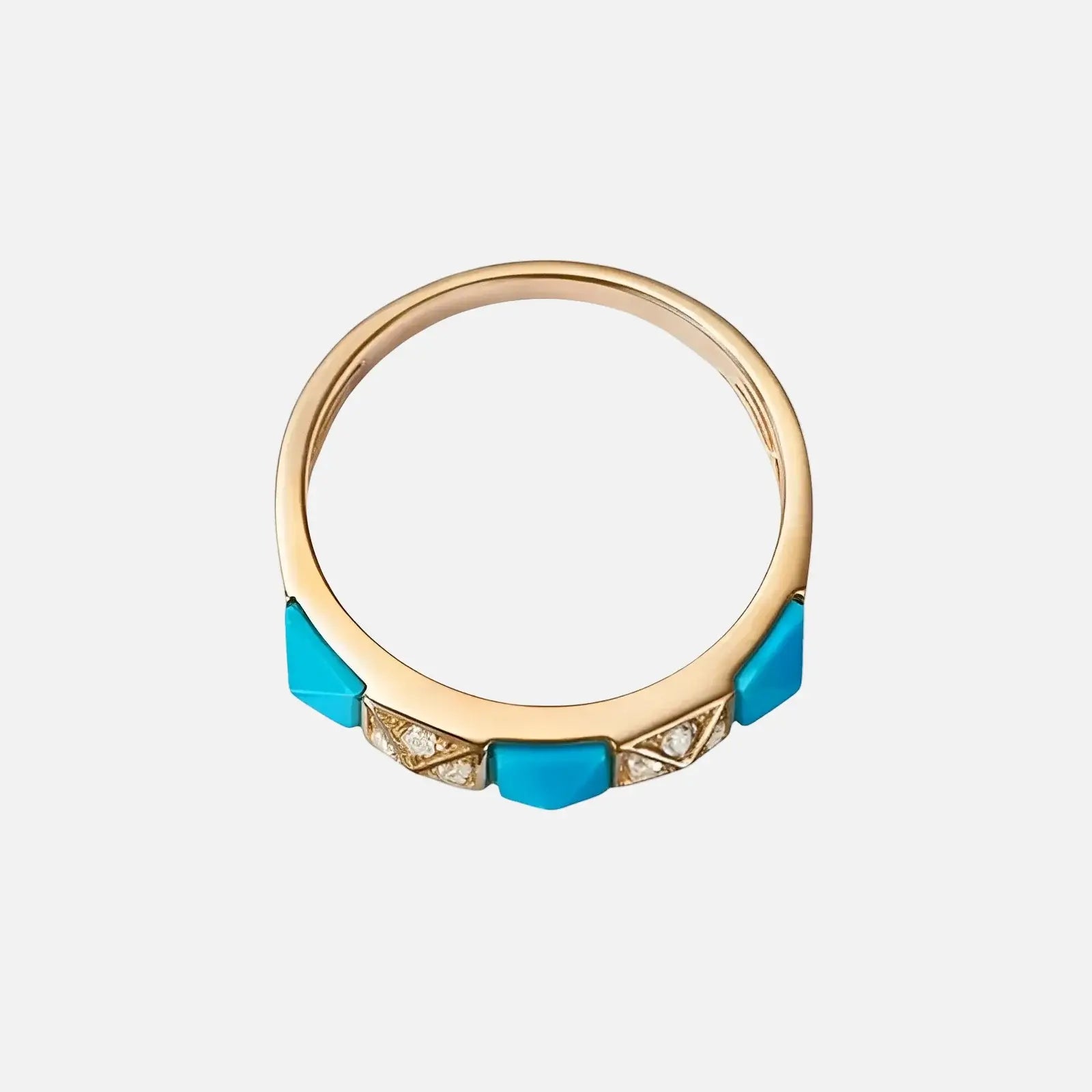 Gold ring with blue gemstones on a white background