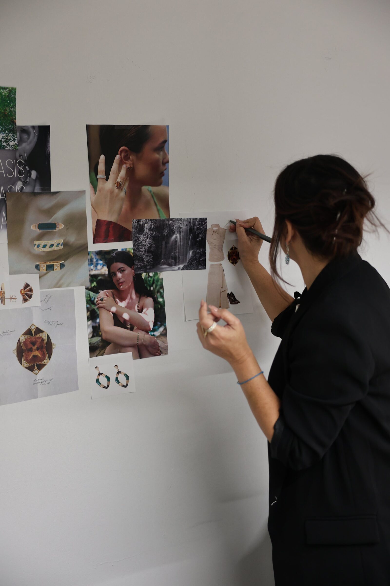 Elda arranging photographs on a white wall